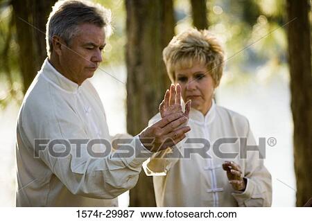 Mature man teaching martial arts to mature woman in the park View Large Photo Image Stock Photo - Mature man teaching martial arts to mature woman in the park. Fotosearch