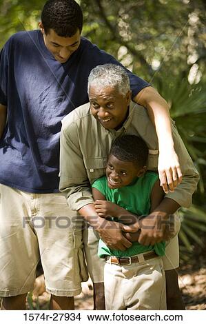 Picture - Mature man with his son and friend at forest. Fotosearch