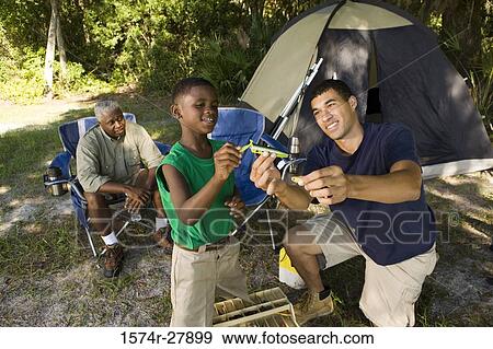 Mature man with his son and friend by tent at forest View Large Photo Image Stock Photo - Mature man with his son and friend by tent at forest. Fotosearch