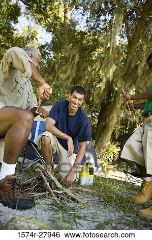 Mature man with his son and friend by sticks View Large Photo Image Stock Photograph - Mature man with his son and friend by sticks. Fotosearch