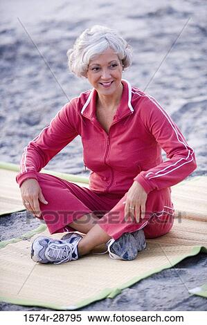 Stock Photography - Mature woman exercising at the beach. Fotosearch