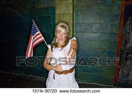 Stock Image - Mature woman holding a American flag and gesturing. Fotosearch