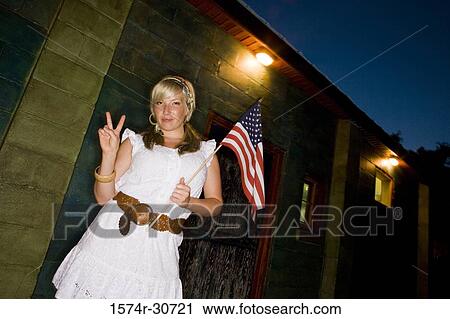 Stock Image - Mature woman holding a American Flag and gesturing. Fotosearch