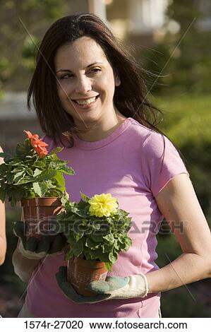 Mature woman holding potted plants View Large Photo Image Stock Image - Mature woman holding potted plants. Fotosearch