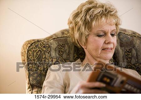 Picture - Mature woman reading a book. Fotosearch