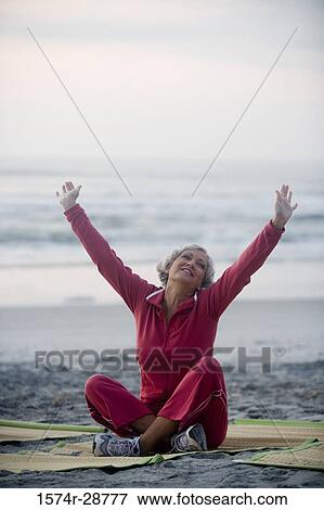 Stock Photo - Mature woman relaxing at the beach. Fotosearch