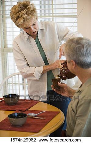 Mature woman serving tea to a man View Large Photo Image Stock Image - Mature woman serving tea to a man. Fotosearch