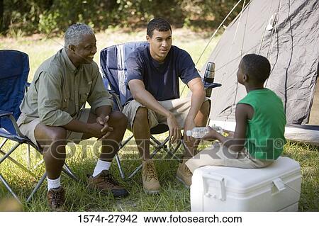 Men conversing with a boy by tent View Large Photo Image Stock Image - Men conversing with a boy by tent. Fotosearch