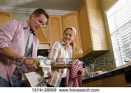 Mid adult couple cleaning bowl in the kitchen View Large Photo Image Stock Photo - Mid adult couple cleaning bowl in the kitchen. Fotosearch