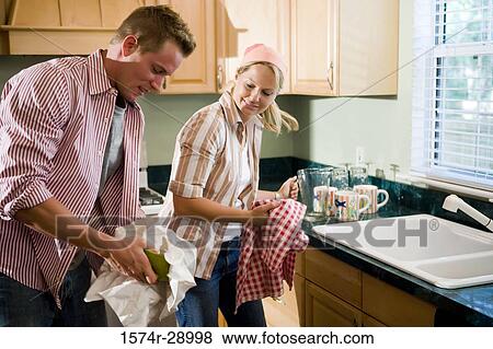 Mid adult couple cleaning bowl in the kitchen View Large Photo Image Stock Photo - Mid adult couple cleaning bowl in the kitchen. Fotosearch