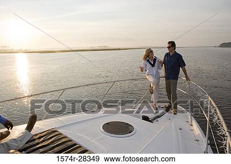 Mid adult couple conversing at bow of a boat View Large Photo Image Stock Photo - Mid adult couple conversing at bow of a boat. Fotosearch
