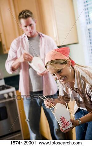Mid adult couple eating fast food in the kitchen View Large Photo Image Stock Image - Mid adult couple eating fast food in the kitchen. Fotosearch