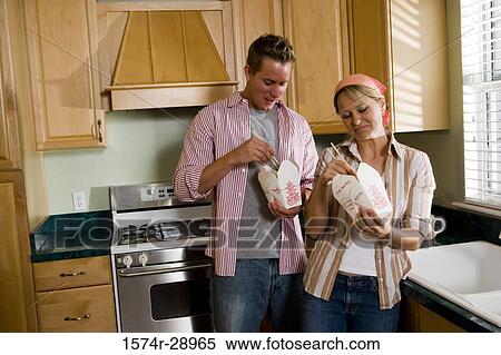 Mid adult couple eating fast food in the kitchen View Large Photo Image Stock Photography - Mid adult couple eating fast food in the kitchen. Fotosearch