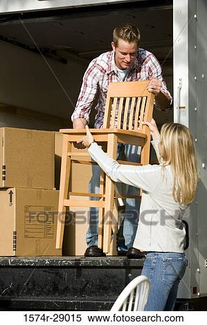Mid adult couple unloading chairs and cardboard boxes from a moving van View Large Photo Image Stock Photography - Mid adult couple unloading chairs and cardboard boxes from a moving van. Fotosearch