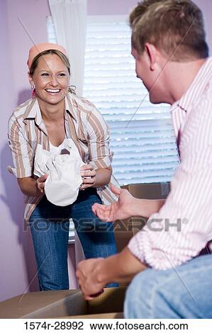 Mid adult couple unpacking cardboard box in a house View Large Photo Image Stock Image - Mid adult couple unpacking cardboard box in a house. Fotosearch