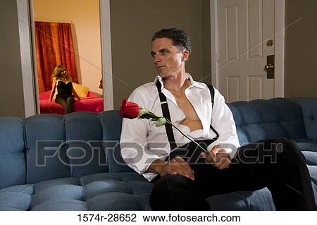 Mid adult man holding a rose while a young prostitute sitting in the background View Large Photo Image Stock Image - Mid adult man holding a rose while a young prostitute sitting in the background. Fotosearch
