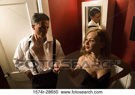Stock Image - Mid adult man holding hand of a young prostitute. Fotosearch