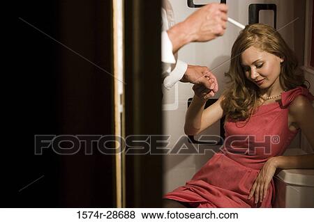 Stock Photo - Mid adult man holding hand of a young prostitute. Fotosearch