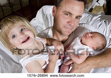 Mid adult man holding his baby and daughter View Large Photo Image Picture - Mid adult man holding his baby and daughter. Fotosearch