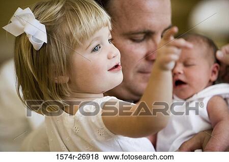 Mid adult man holding his baby and daughter View Large Photo Image Stock Photo - Mid adult man holding his baby and daughter. Fotosearch