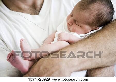 Mid adult man holding his baby View Large Photo Image Stock Photo - Mid adult man holding his baby. Fotosearch