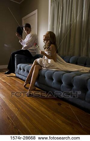 Mid adult man sitting by a young prostitute on sofa View Large Photo Image Stock Photo - Mid adult man sitting by a young prostitute on sofa. Fotosearch