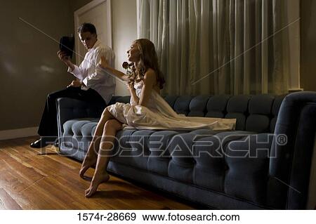Mid adult man sitting by a young prostitute on sofa View Large Photo Image Stock Photo - Mid adult man sitting by a young prostitute on sofa. Fotosearch