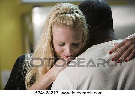 Stock Image - Mid adult woman embracing young man. Fotosearch
