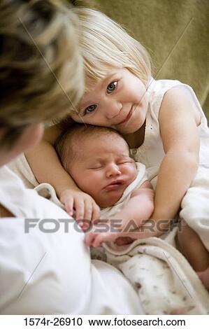 Mid adult woman holding her baby and daughter View Large Photo Image Stock Image - Mid adult woman holding her baby and daughter. Fotosearch