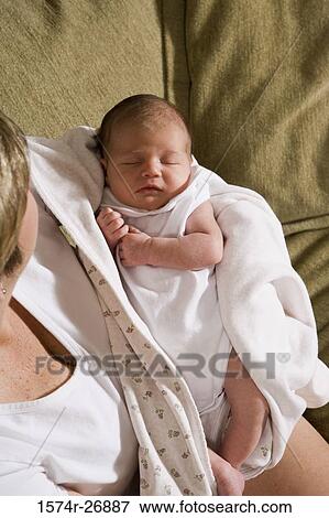 Stock Photo - Mid adult woman holding her baby in hands. Fotosearch