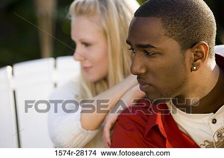 Mid adult woman leaning on young man and looking away View Large Photo Image Picture - Mid adult woman leaning on young man and looking away. Fotosearch
