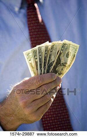Stock Photo - Midsection of a businessman holding American dollars. Fotosearch