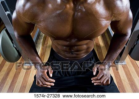 Midsection of a shirtless man after working out in the gym View Large Photo Image Stock Photo - Midsection of a shirtless man after working out in the gym. Fotosearch