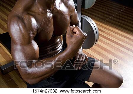 Midsection of a young man flexing muscles in the gym View Large Photo Image Stock Image - Midsection of a young man flexing muscles in the gym. Fotosearch