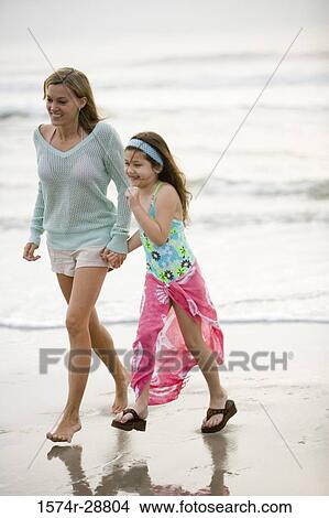 Mother enjoying with her daughter at the beach View Large Photo Image Picture - Mother enjoying with her daughter at the beach. Fotosearch
