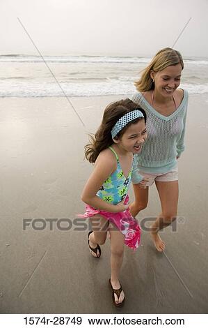 Stock Photo - Mother enjoying with her daughter at the beach. Fotosearch