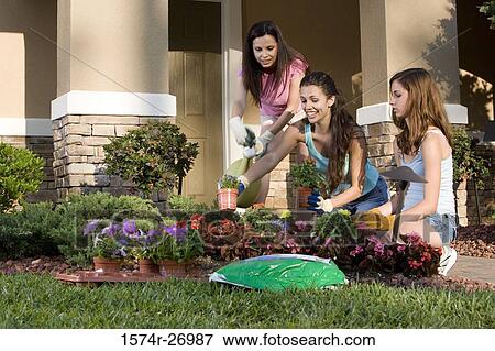 Stock Photo - Mother gardening with her daughters in garden. Fotosearch