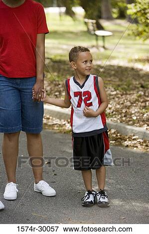 Mother holding hands of her son on the road View Large Photo Image Stock Photo - Mother holding hands of her son on the road. Fotosearch