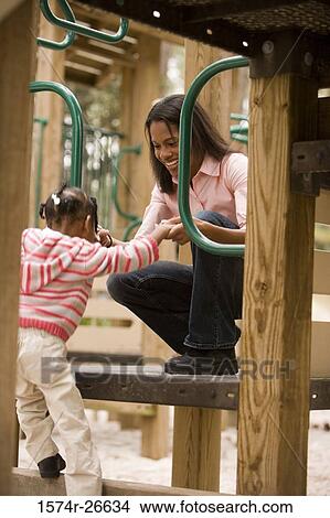 Mother playing with her daughter at park View Large Photo Image Picture - Mother playing with her daughter at park. Fotosearch