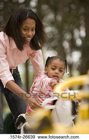 Mother playing with her daughter at park View Large Photo Image Stock Photo - Mother playing with her daughter at park. Fotosearch