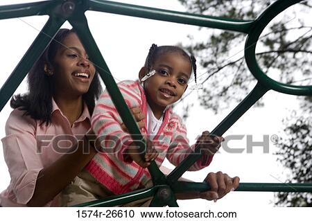 Mother playing with her daughter on jungle gym at park View Large Photo Image Stock Image - Mother playing with her daughter on jungle gym at park. Fotosearch