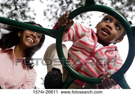 Mother playing with her daughter on jungle gym at park View Large Photo Image Stock Image - Mother playing with her daughter on jungle gym at park. Fotosearch