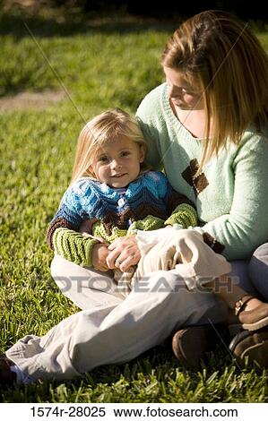 Mother sitting with her daughter on grass View Large Photo Image Stock Photography - Mother sitting with her daughter on grass. Fotosearch