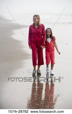 Mother walking with her daughter at the beach View Large Photo Image Stock Image - Mother walking with her daughter at the beach. Fotosearch
