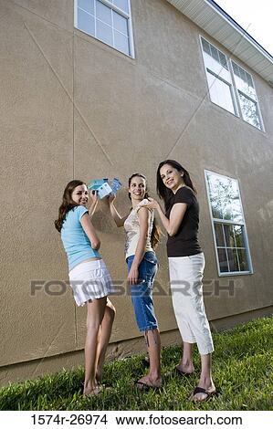 Picture - mother with her daughters holding color swatches against wall. Fotosearch