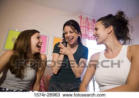 Stock Image - Mother with her daughters smiling in bedroom. Fotosearch