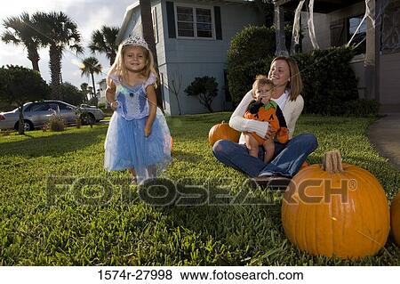 Mother with her son looking at her daughter dressed as a princess View Large Photo Image Stock Photo - Mother with her son looking at her daughter dressed as a princess. Fotosearch