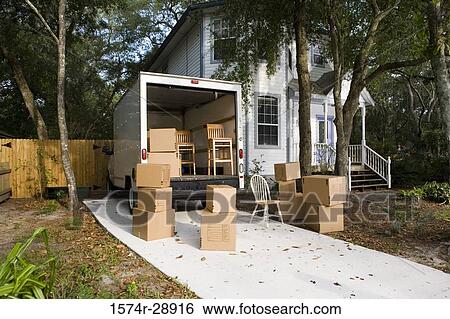 Moving van with cardboard box and chairs by house View Large Photo Image Stock Photograph - Moving van with cardboard box and chairs by house. Fotosearch