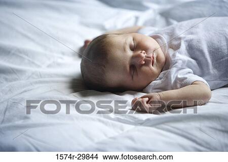 Newborn baby sleeping on the bed View Large Photo Image Picture - Newborn baby sleeping on the bed. Fotosearch