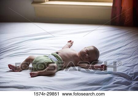 Stock Image - Newborn baby sleeping on the bed. Fotosearch